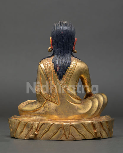 Back view of a handcrafted Milarepa statue showing a gold-gilded copper finish and an intricately carved lotus throne petal relief design