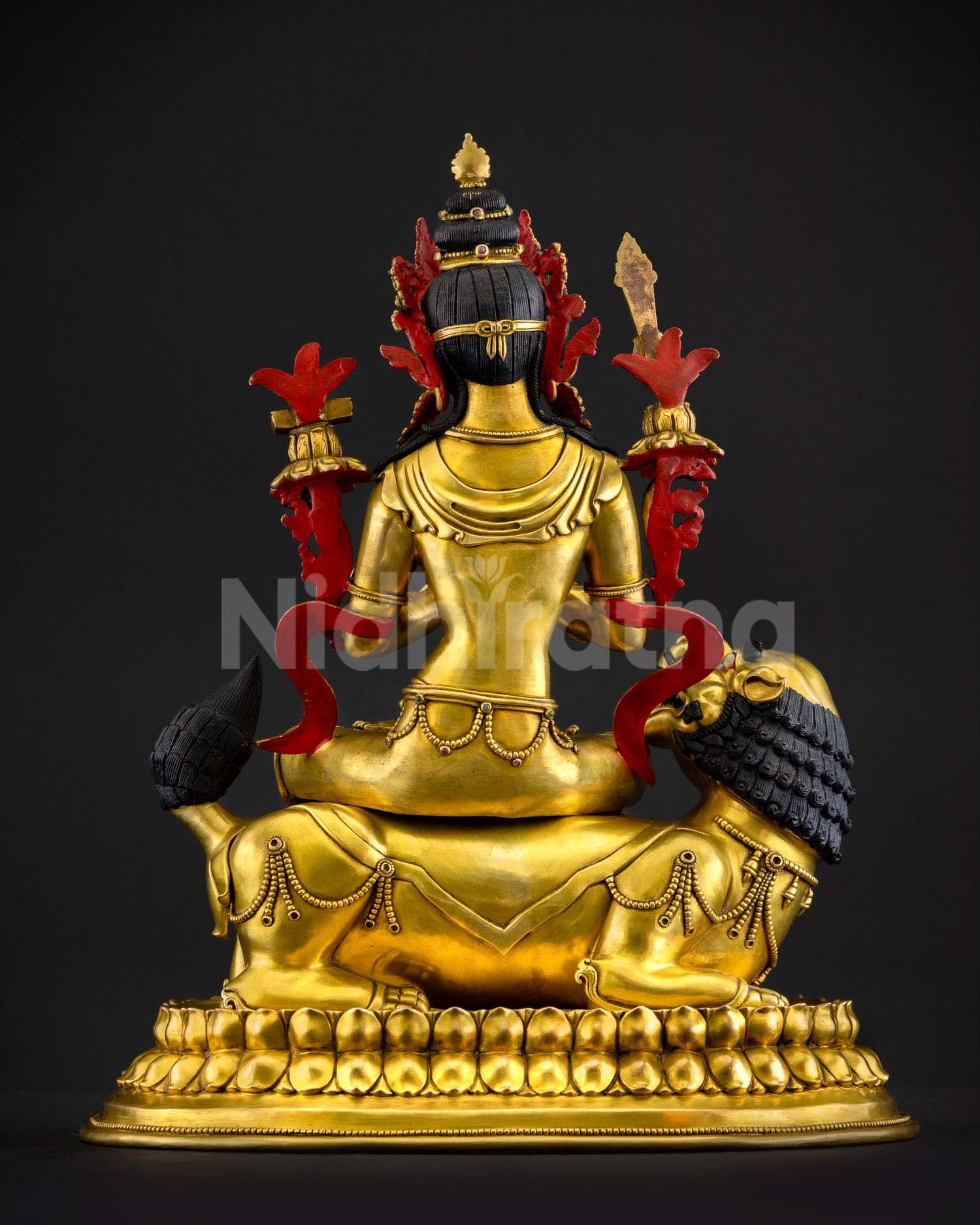 Back view of handcrafted Simhanada Manjushri statue from Patan Nepal showing traditional lost wax metal craftsmanship gold gilding layers and detailed lotus base