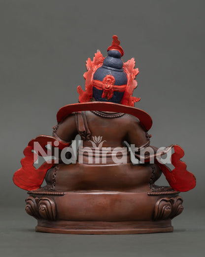 Back view of handmade Dzambhala statue showing oxidized copper finish, silk garment, and ornate details.