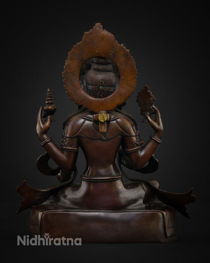 Back view of a handmade Goddess Lakshmi statue displaying an intricate halo design and Himalayan artisan metalwork