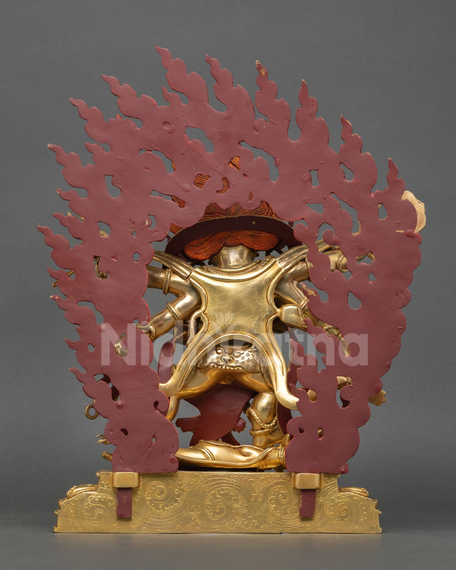 Back view of a handmade Mahakala statue showcasing intricate Himalayan craftsmanship and a detailed flame halo design