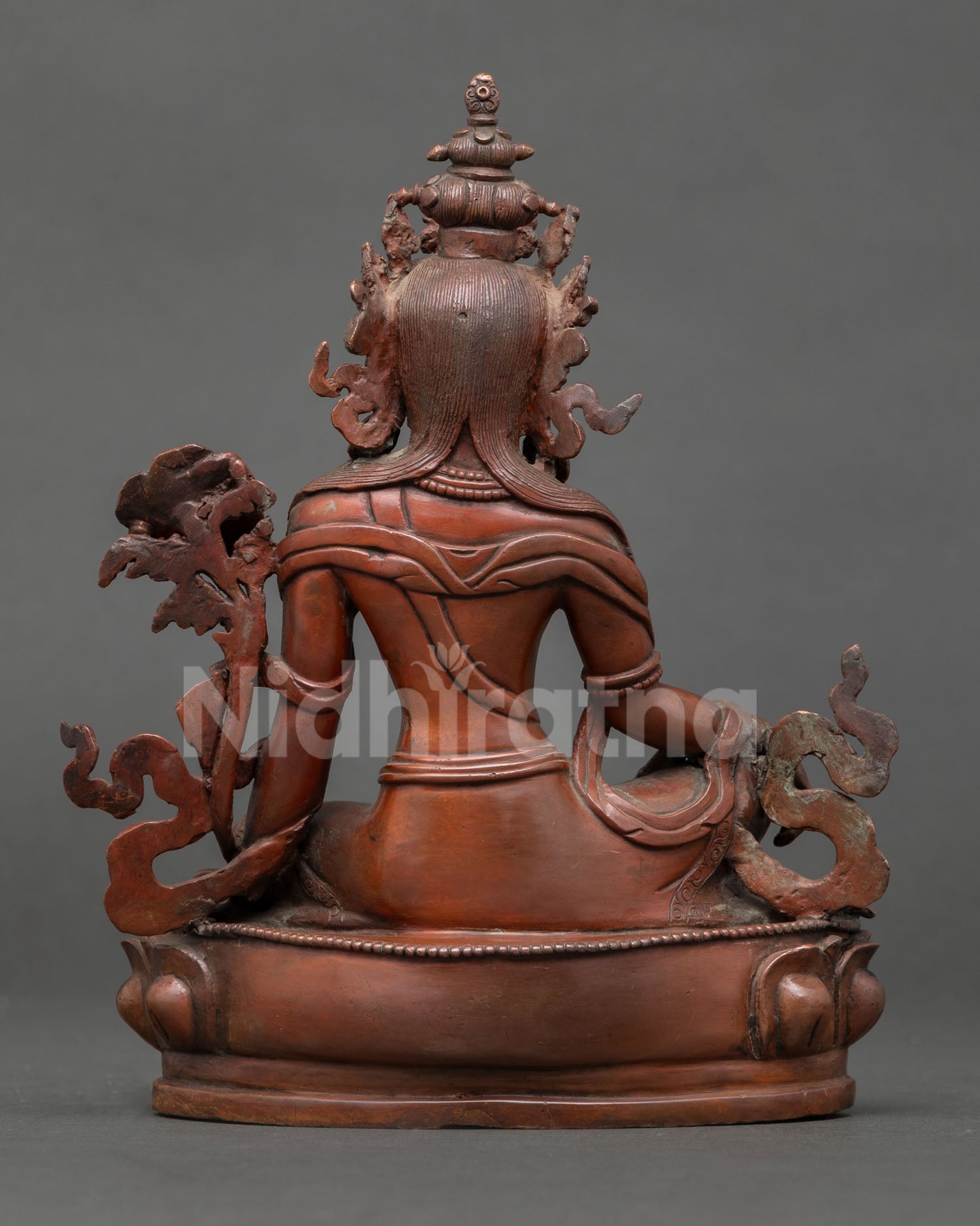 back view of lokeshvara statue showing detailed crown, robes, lotus base and oxidized copper texture