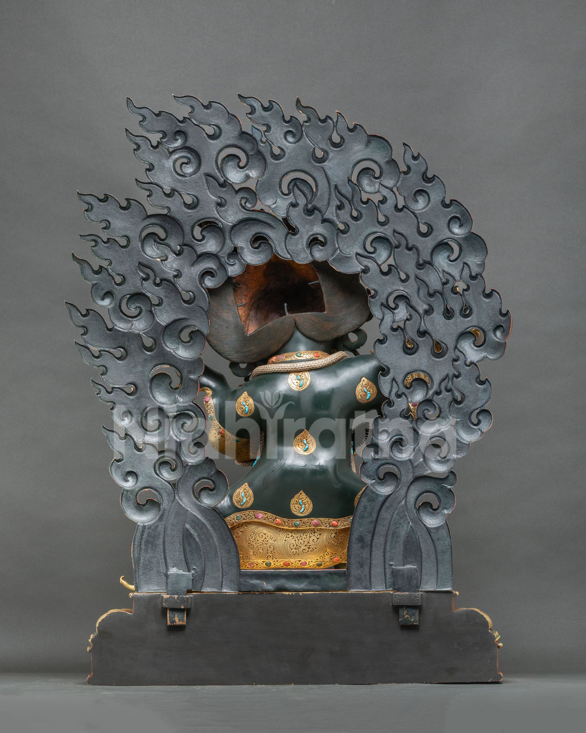 Back view of Mahakala Bernagchen statue showing openwork flame halo and pedestal