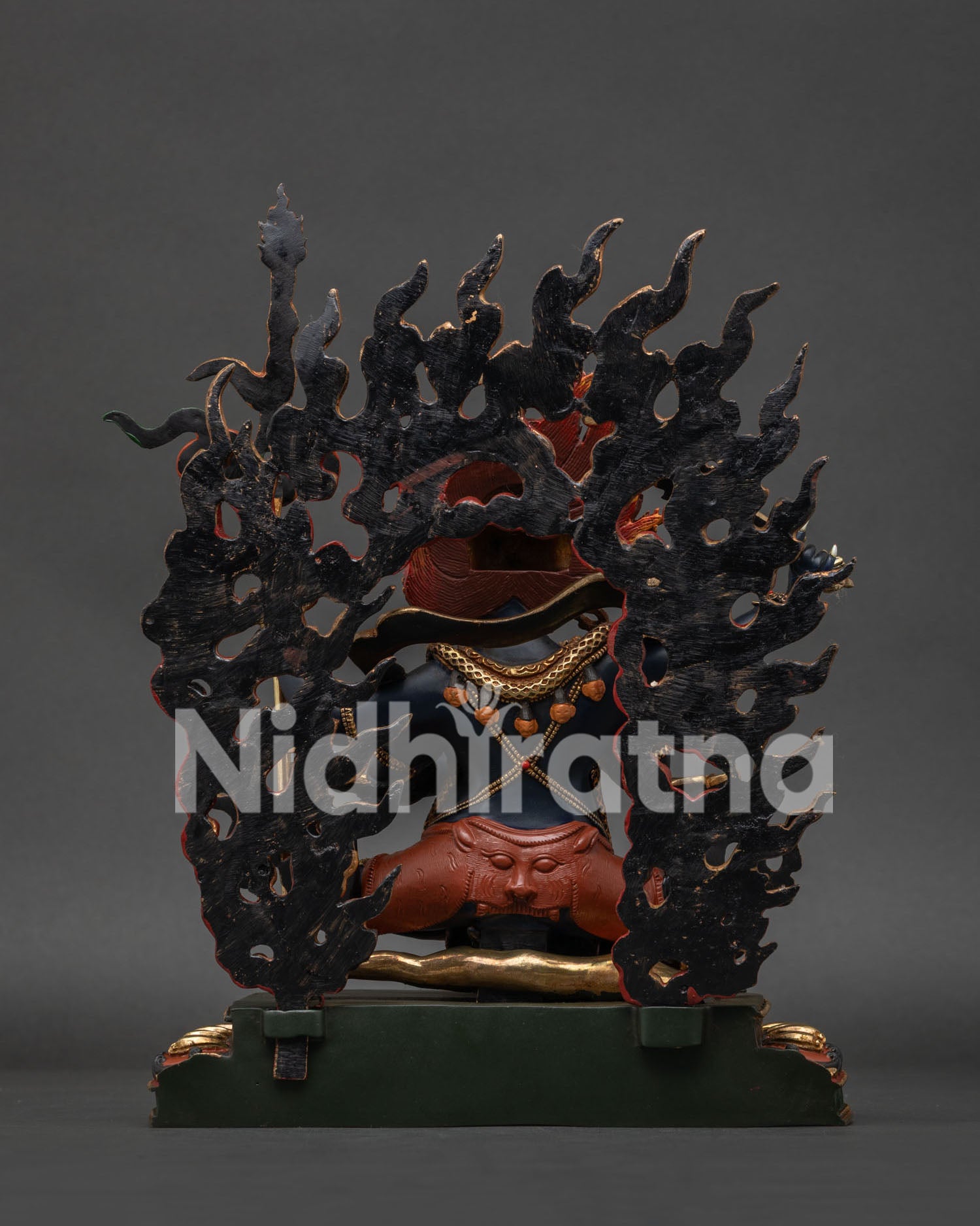 Back view of Mahakala statue showing flaming halo and lotus pedestal