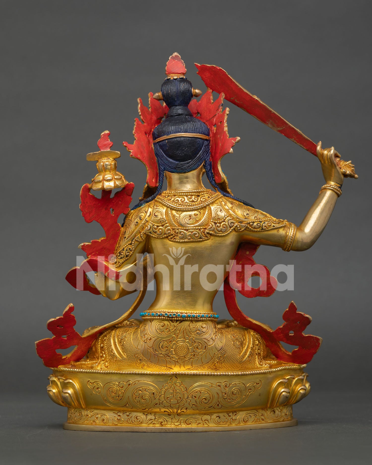 back view of manjushri statue featuring detailed repoussé work and ornate halo