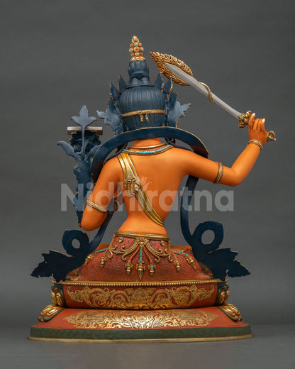 Back view of Manjushri Statue revealing repoussé garment details and radiant acrylic-painted copper surface