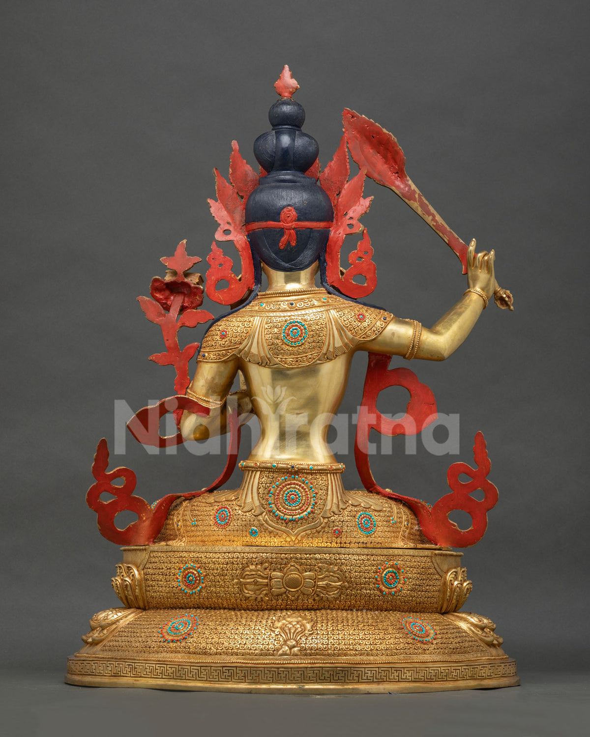 Back view of Manjushri statue showing gold gilded crown and lotus base, Nepal