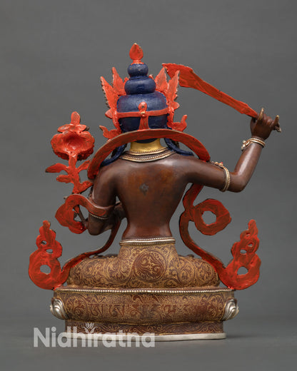 back view of manjushri statue with engraved lotus seat and sacred mantra inscription
