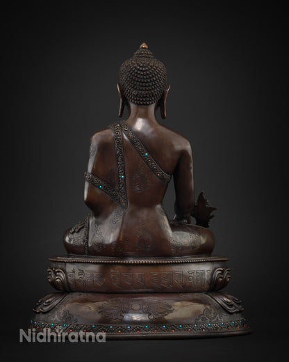 Back view of Medicine Buddha statue with engraved mantra on lotus base, Nepalese copper sculpture