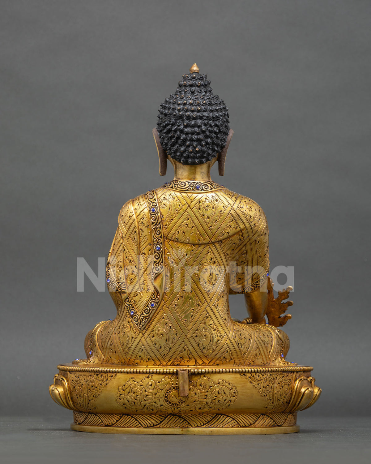 Back view of Medicine Buddha statue with hand-engraved robe and lotus base, handmade in Nepal