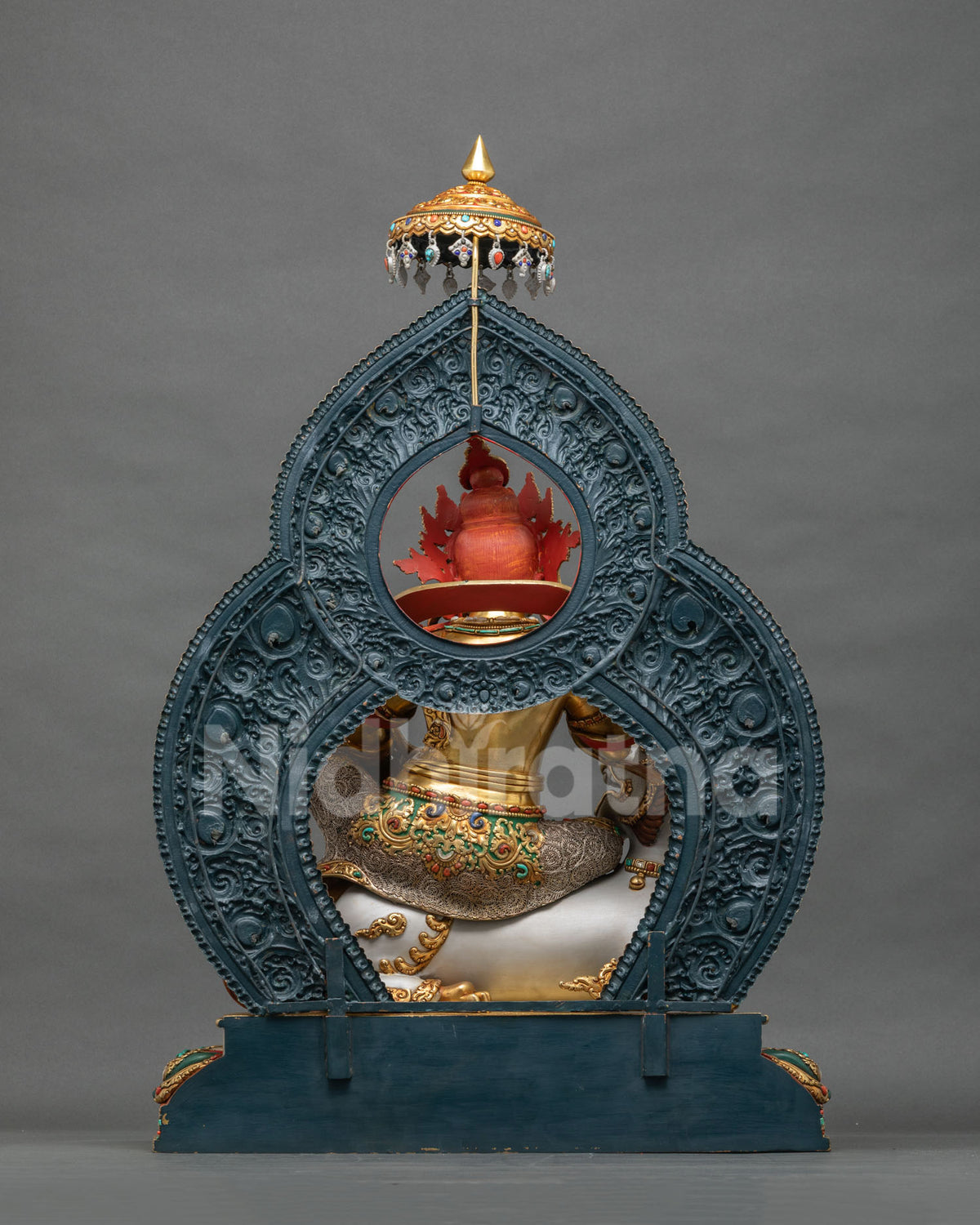 Back view of Namtoshe statue showing gold-gilded copper body and red crown detail