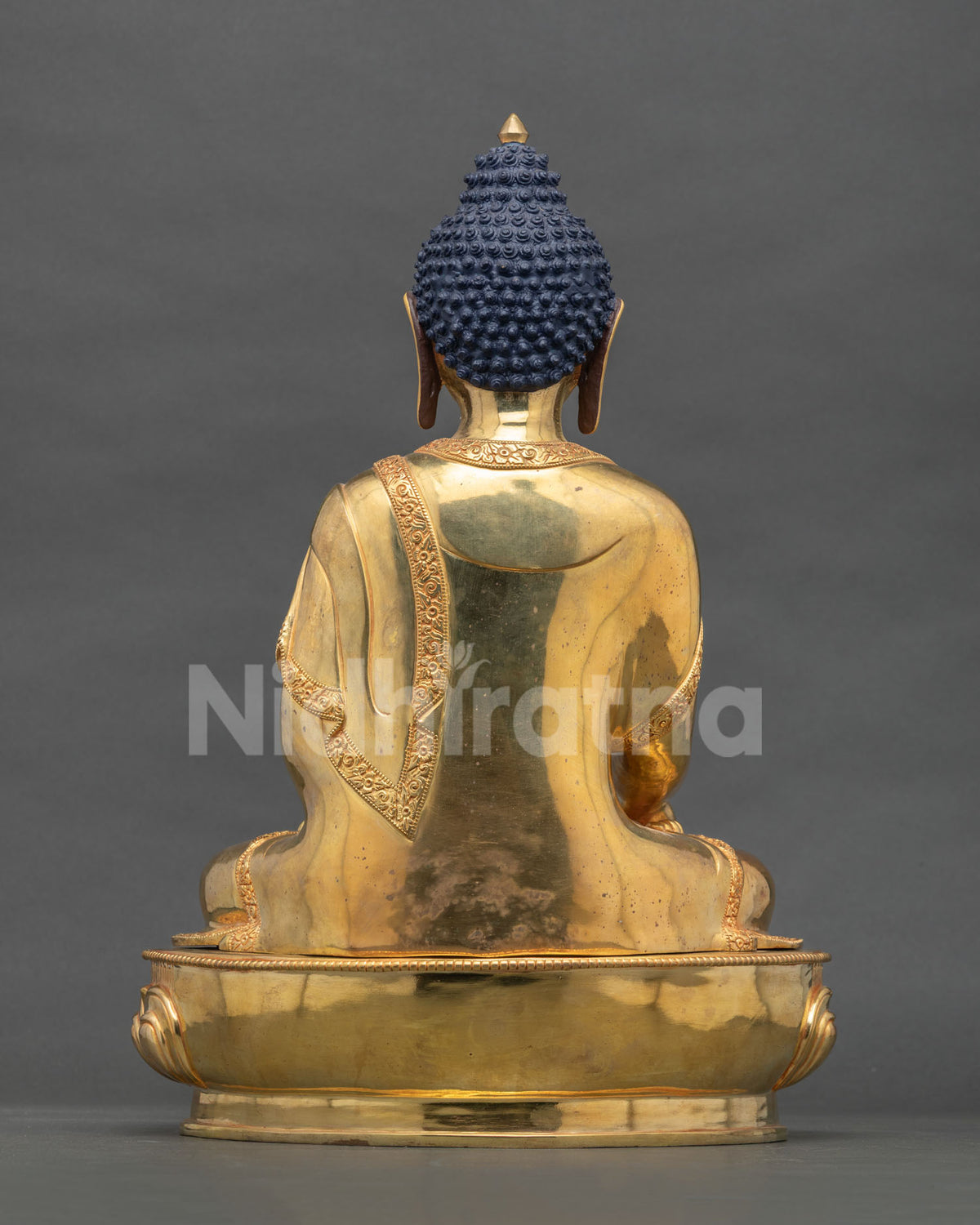 Back view of Nepali Shakyamuni Buddha statue showing gold-gilded copper robe and lotus base