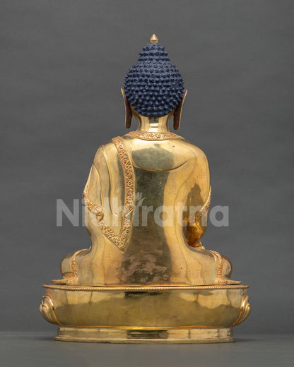 Back view of Nepali Shakyamuni Buddha statue showing gold-gilded copper robe and lotus base