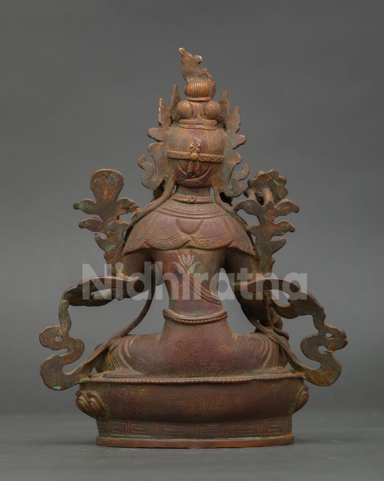 Back view of oxidized copper green tara statue featuring detailed craftsmanship and antique patina