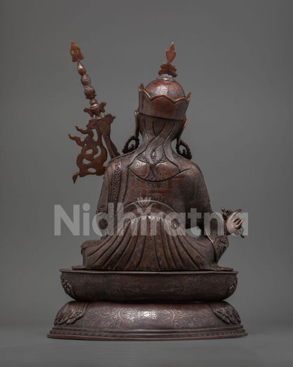 Back view of oxidized copper Guru Rinpoche statue showing engraved robe and lotus base