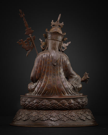 Back view of oxidized copper Guru Rinpoche statue showing engraved robe and lotus base