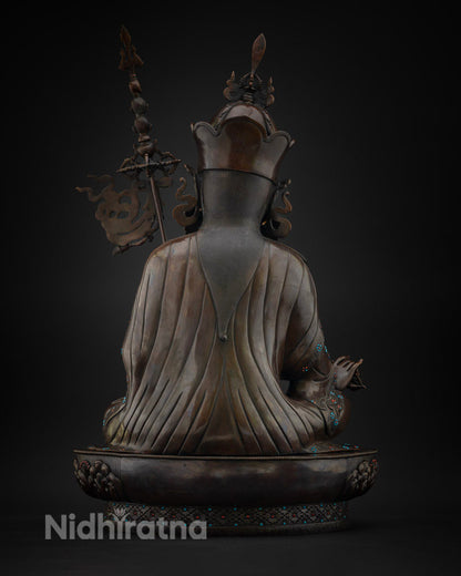 Back view of oxidized copper Guru Rinpoche statue showing robe and staff