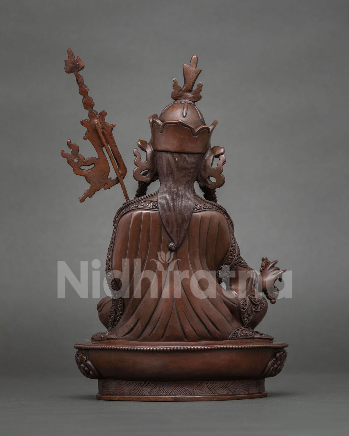 Back view of oxidized copper Guru Rinpoche statue with khatvanga staff