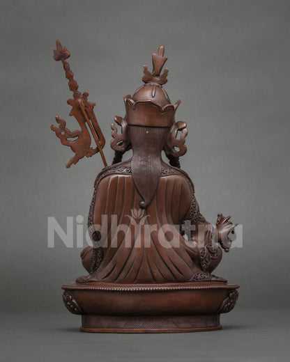 Back view of oxidized copper Guru Rinpoche statue with khatvanga staff