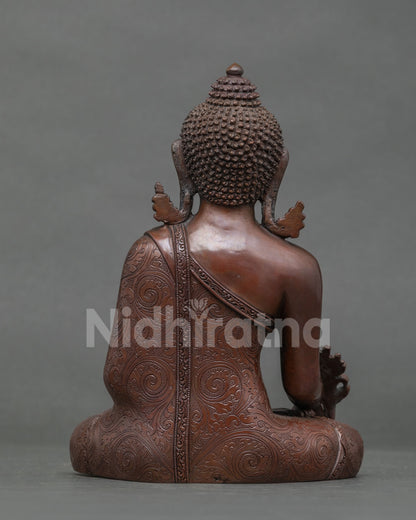 Back view of oxidized copper Medicine Buddha statue showing carved robe and ushnisha
