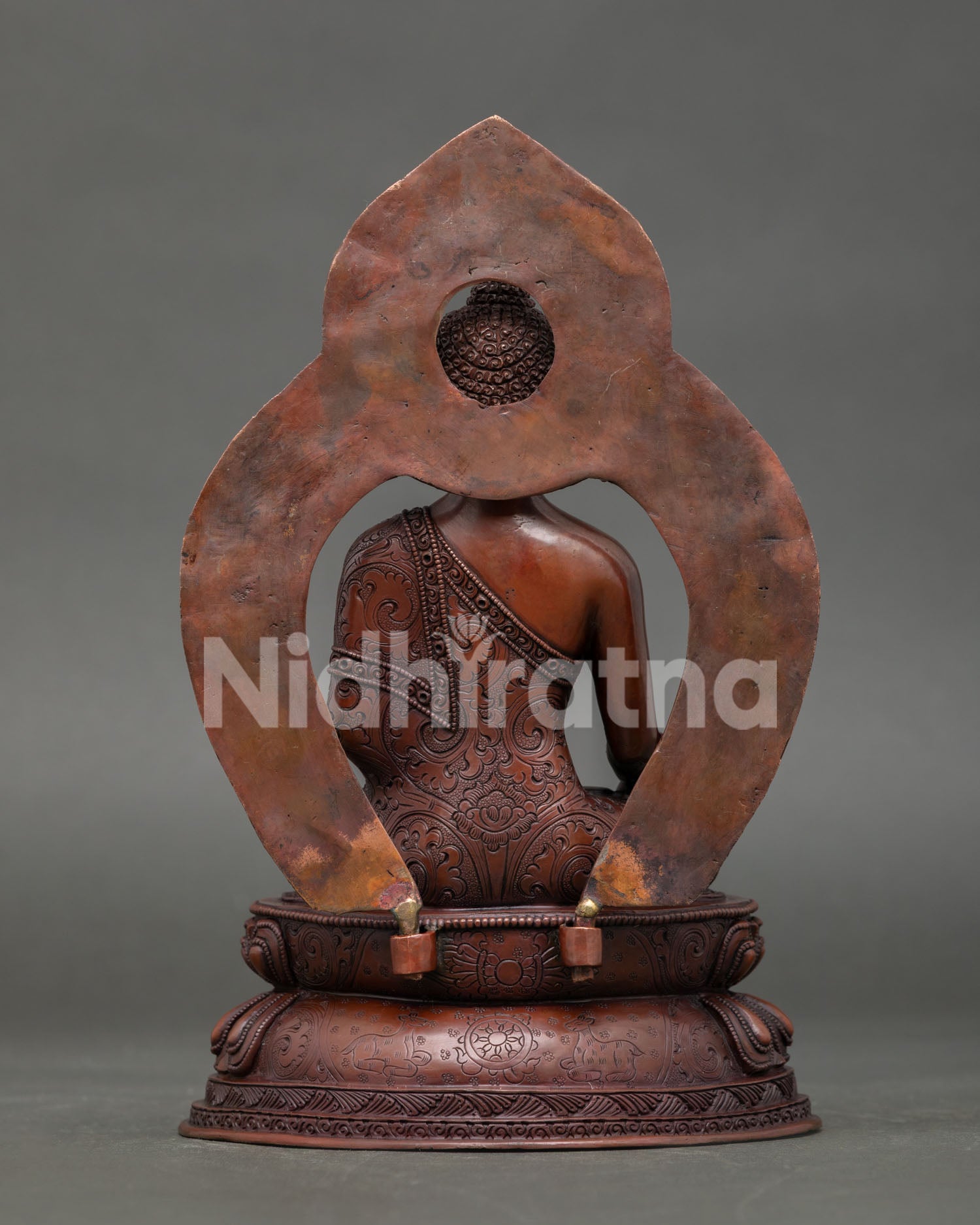 back view of oxidized copper medicine buddha statue with decorative halo details