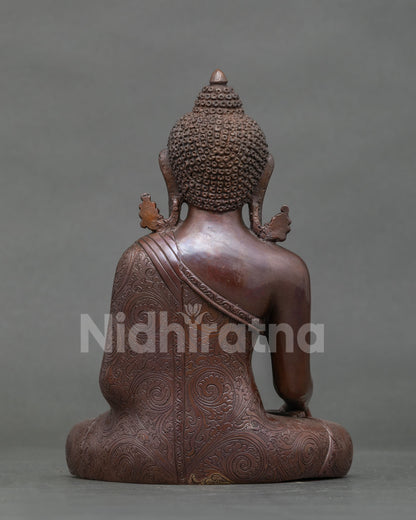 Back view of oxidized copper Shakyamuni Buddha statue showing carved robe and ushnisha