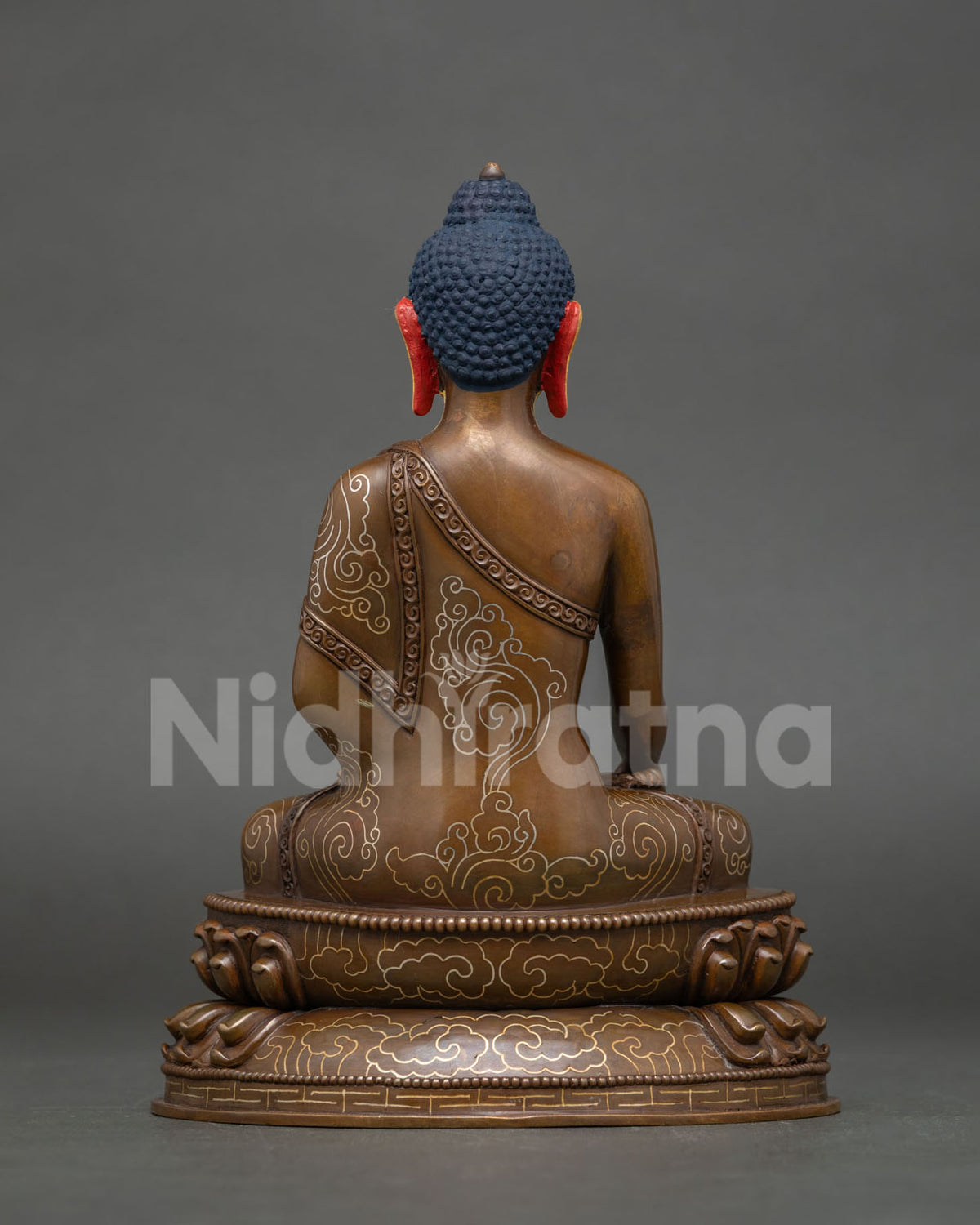 Back view of oxidized copper Shakyamuni Buddha statue with engraved silver-plated cloud motifs