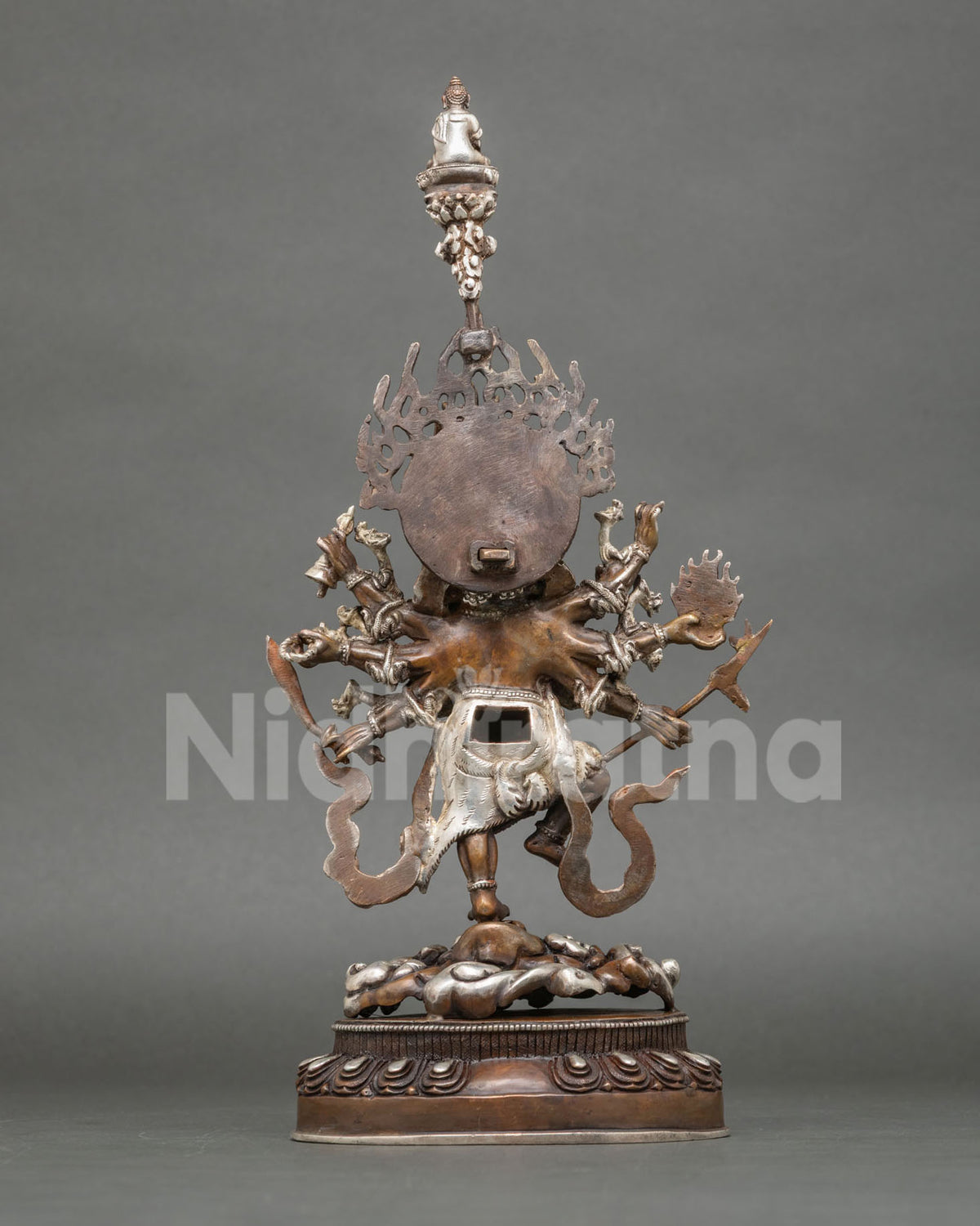 Back view of oxidized copper Ucchusma statue showing multiple arms, flaming halo and miniature Buddha