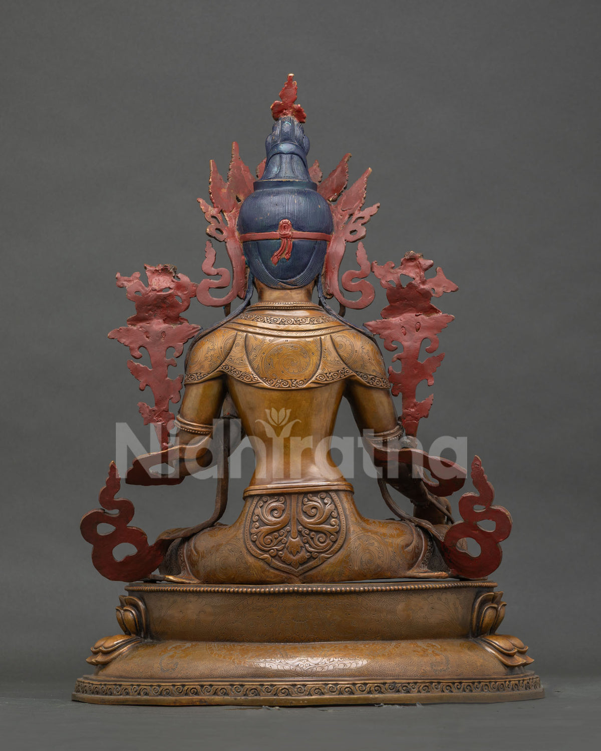 Back view of oxidized copper White Tara statue on carved lotus pedestal
