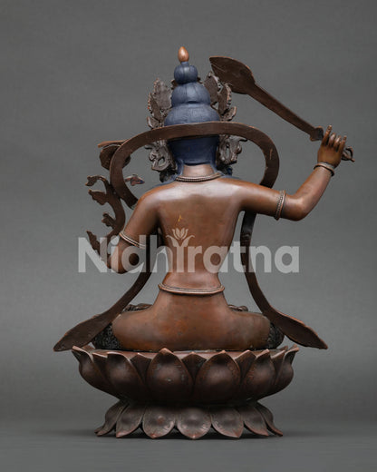 back view of oxidized manjushri statue with intricate copper engraving and lotus seat
