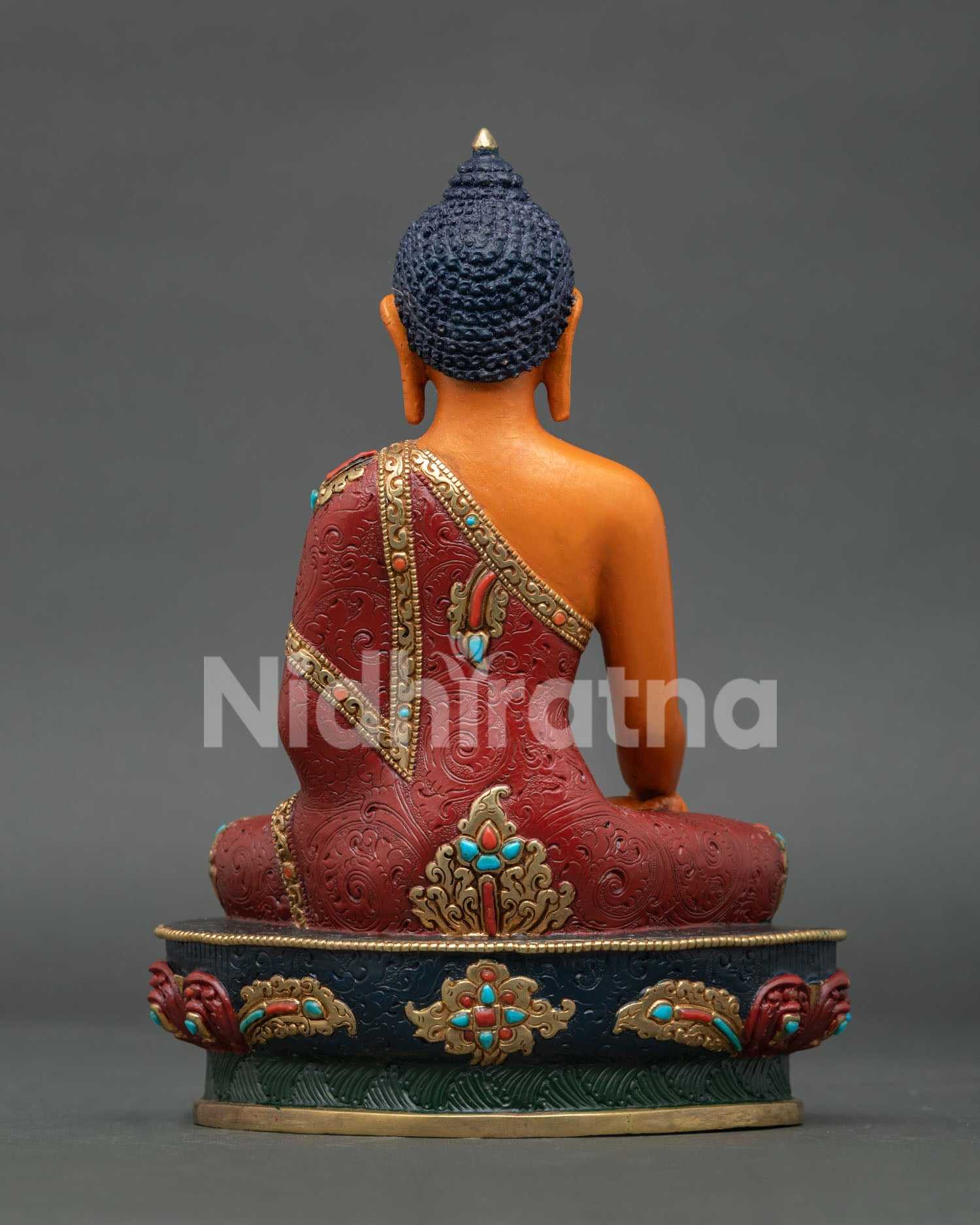 Back view of Shakyamuni Buddha statue showing engraved lotus pedestal details
