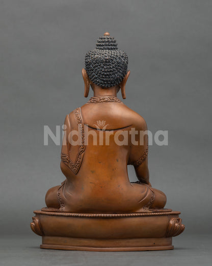 Back view of Shakyamuni Buddha statue showing hand cast copper detail and oxidized brown finish