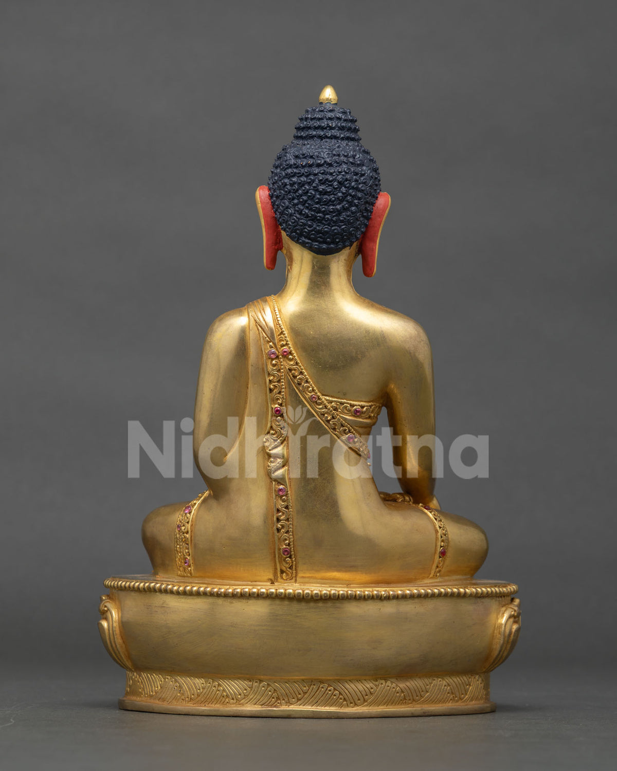 Back view of Shakyamuni Buddha statue showing sanghati robe carving detail