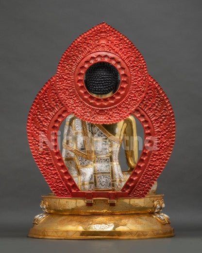 Back view of Shakyamuni Buddha statue with engraved silver robe and red-painted halo