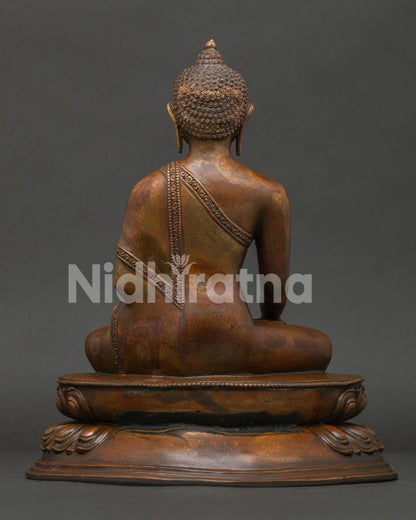 Back view of Shakyamuni Buddha statue with intricate monastic robe carving and traditional Nepalese artisan work.
