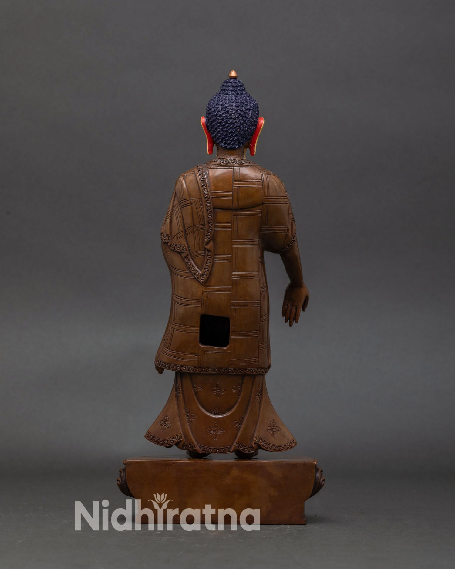 back view of standing buddha statue showing robe patchwork and lotus pedestal design