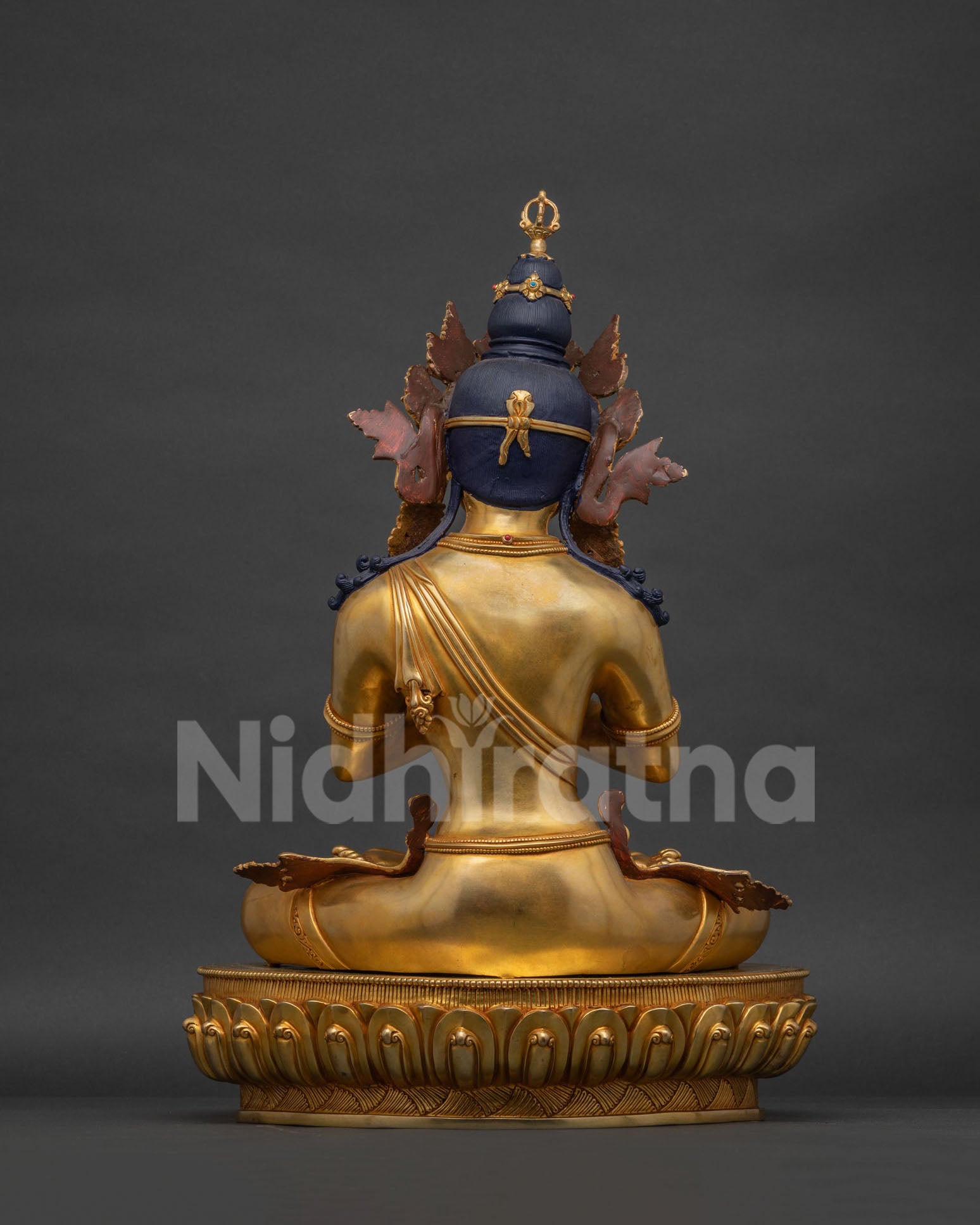 Back view of Vajradhara statue showing hand-chased robe detailing and lotus base