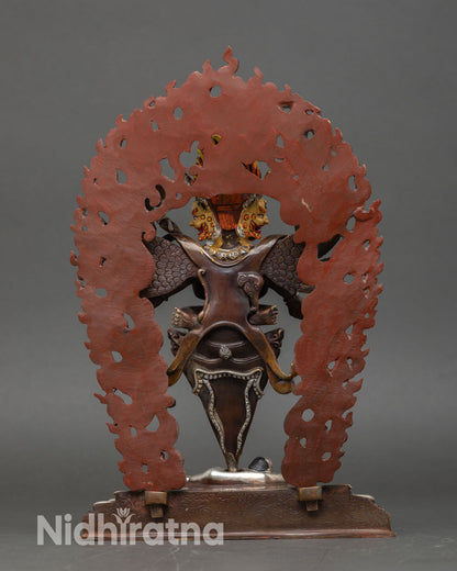 Back view of Vajrakilaya statue with halo and wings in oxidized copper, a symbol of Himalayan spiritual protection.