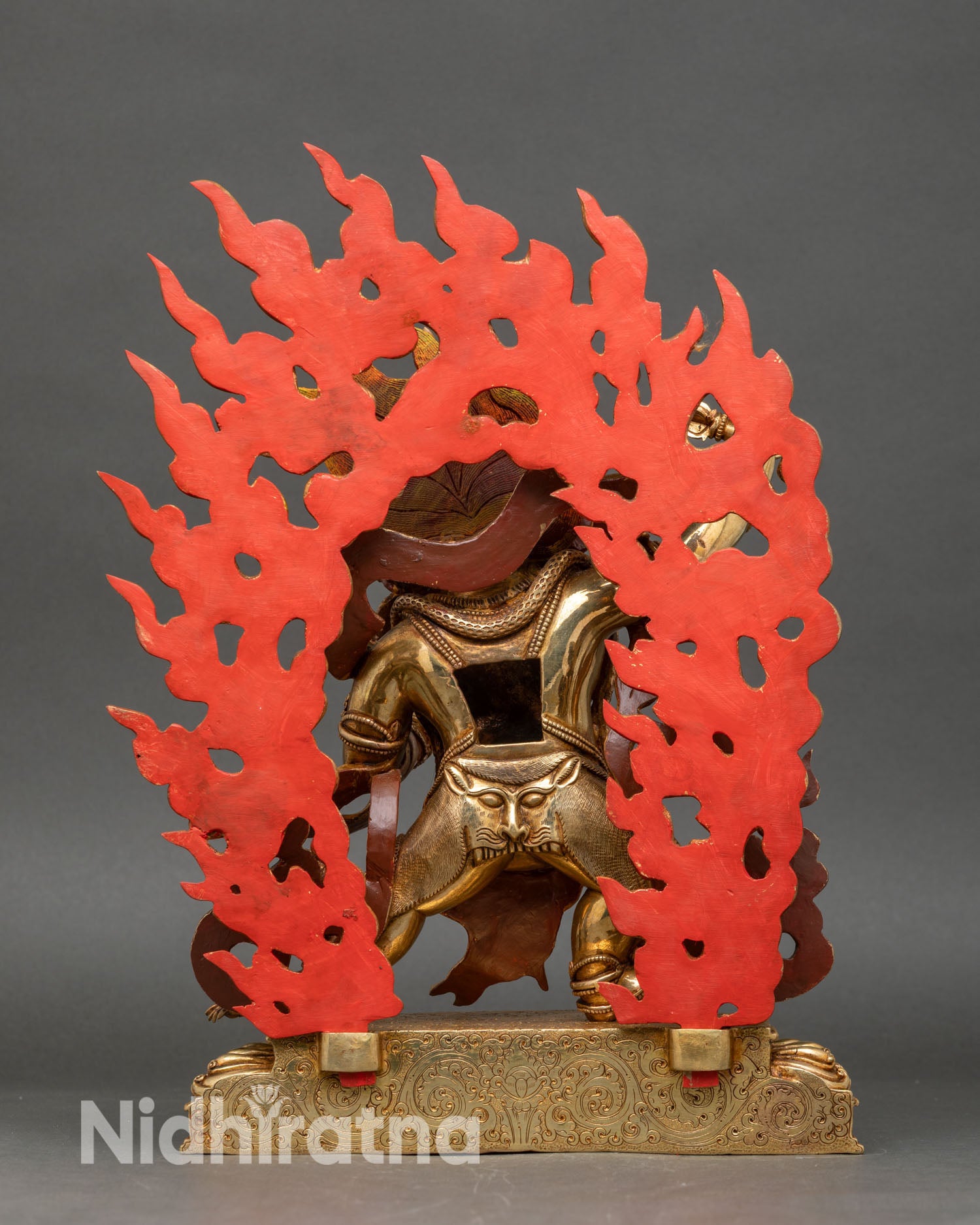 back view of vajrapani buddha statue showing engraved details and lotus base