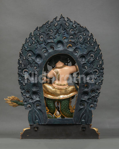 Back view of White Dzambhala statue showing the carved flame halo and scaled dragon, Nepali copper art