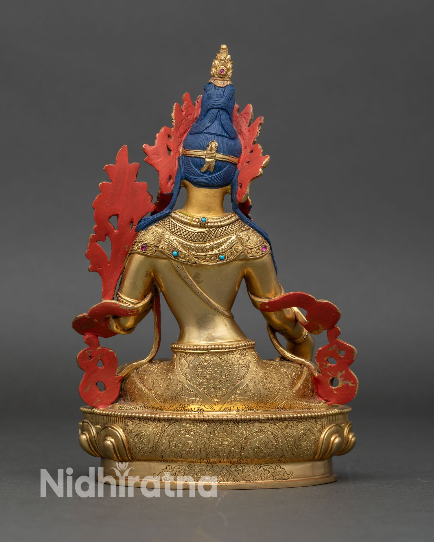 Back view of White Tara meditation statue showing detailed copper and gold workmanship