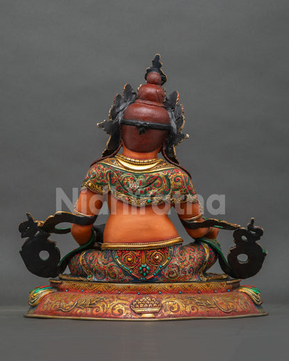 Back view of Yellow Dzambhala copper statue with gold gilded garments and engraved mongoose base