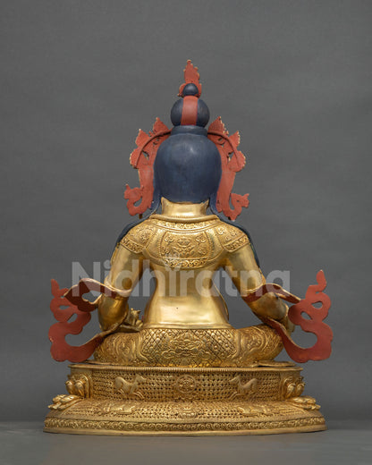 Back view of Yellow Dzambhala statue showing engraved royal garment and gold fire-gilded lotus base