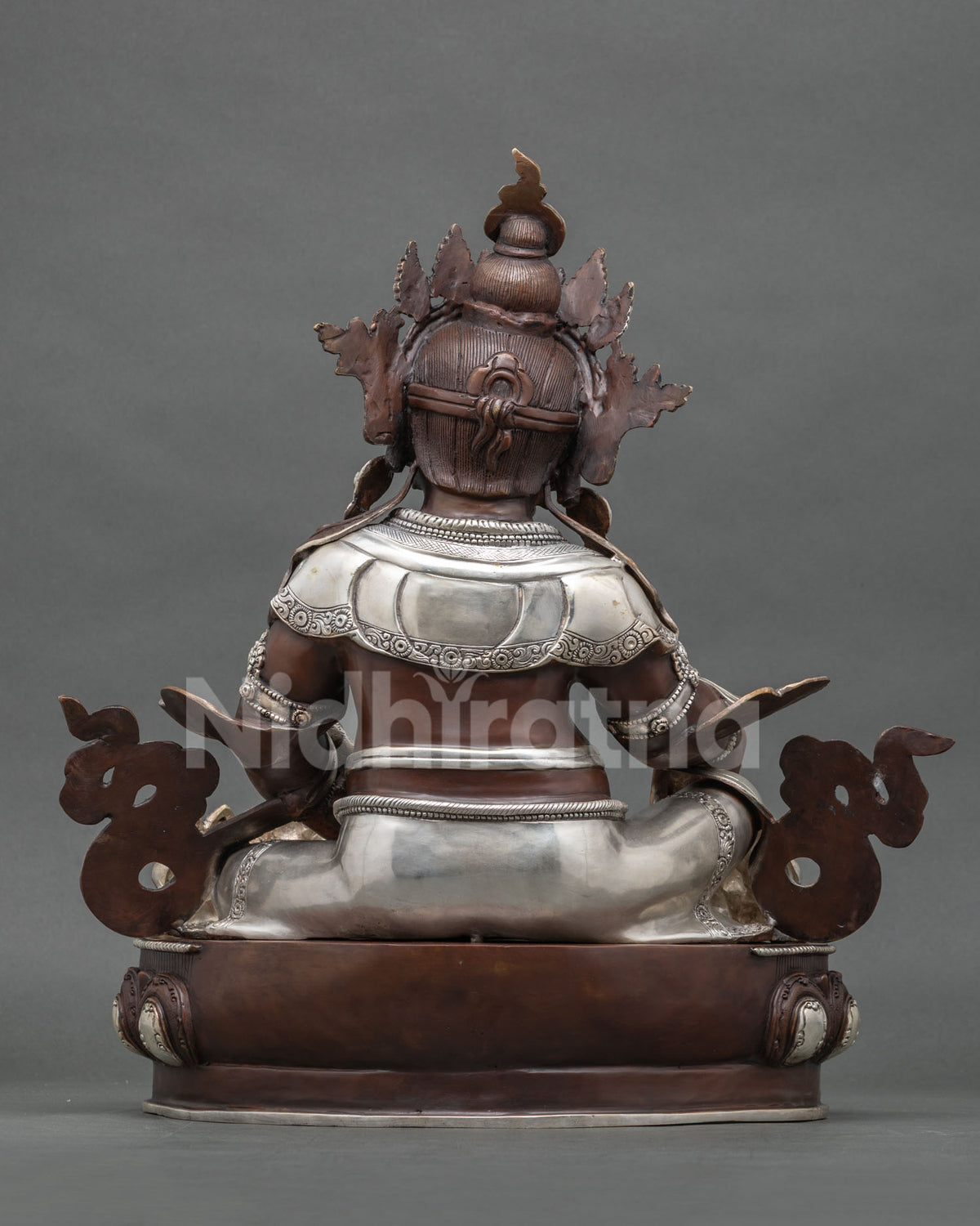 Back view of Yellow Jambhala statue showing oxidized copper finish and silver plated details