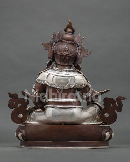 Back view of Yellow Jambhala statue showing oxidized copper finish and silver plated details