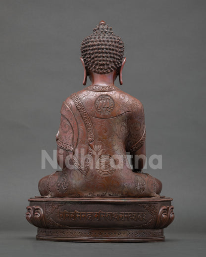 Back view oxidized copper Buddha statue showing engraved lotus base and sacred Tibetan mantra carving