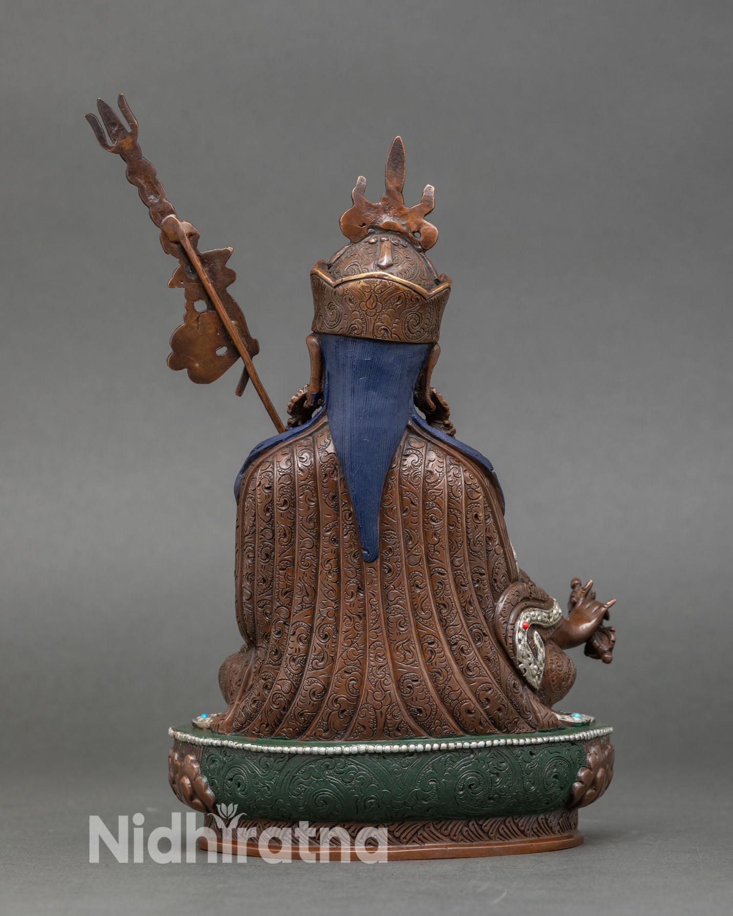 Back view of Guru Rinpoche statue handcrafted in Kathmandu Valley, oxidized copper Himalayan art with intricate detailing for Buddhist shrine and home altar