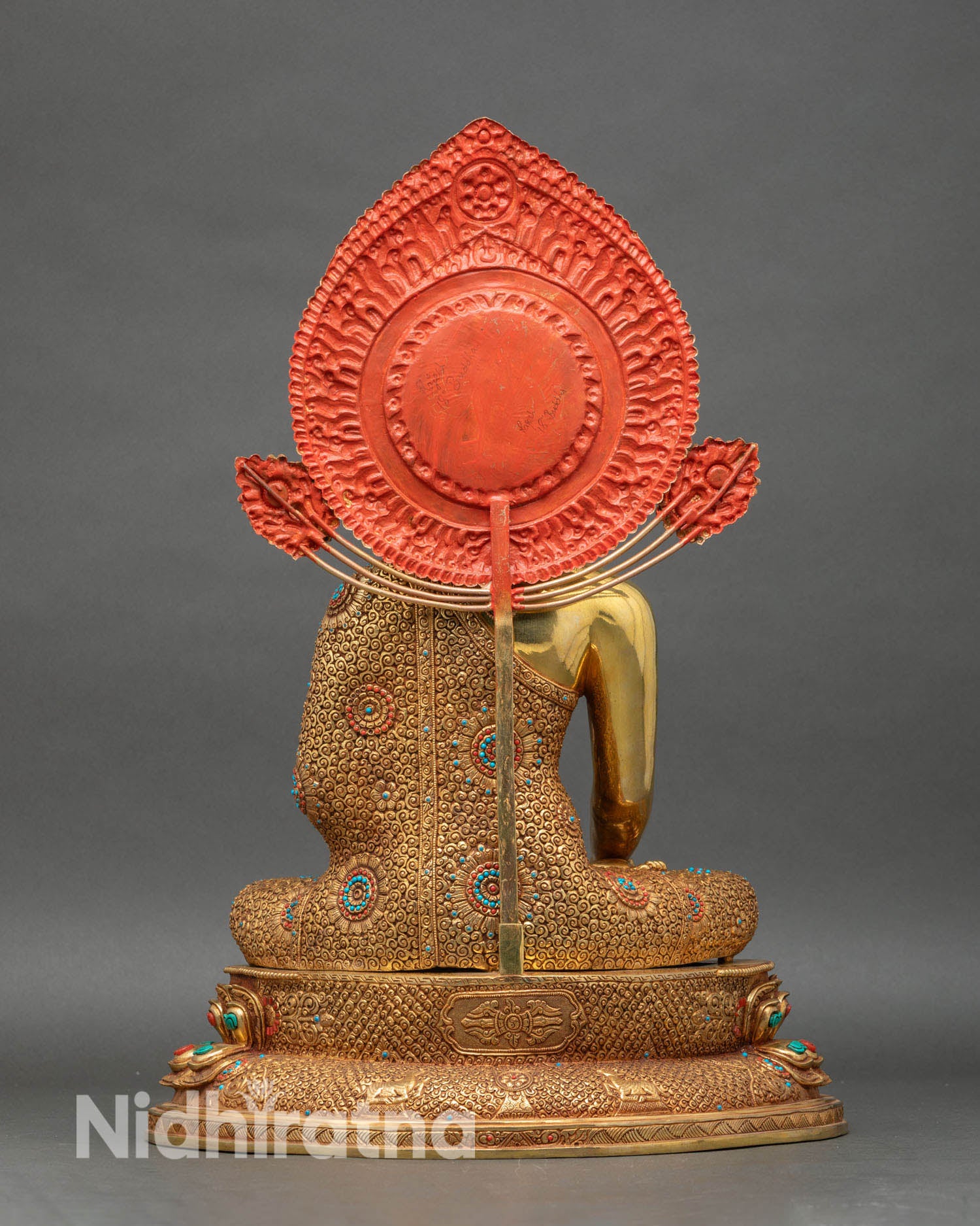 Back view of Shakyamuni Buddha statue, showing engraved halo and lotus throne details
