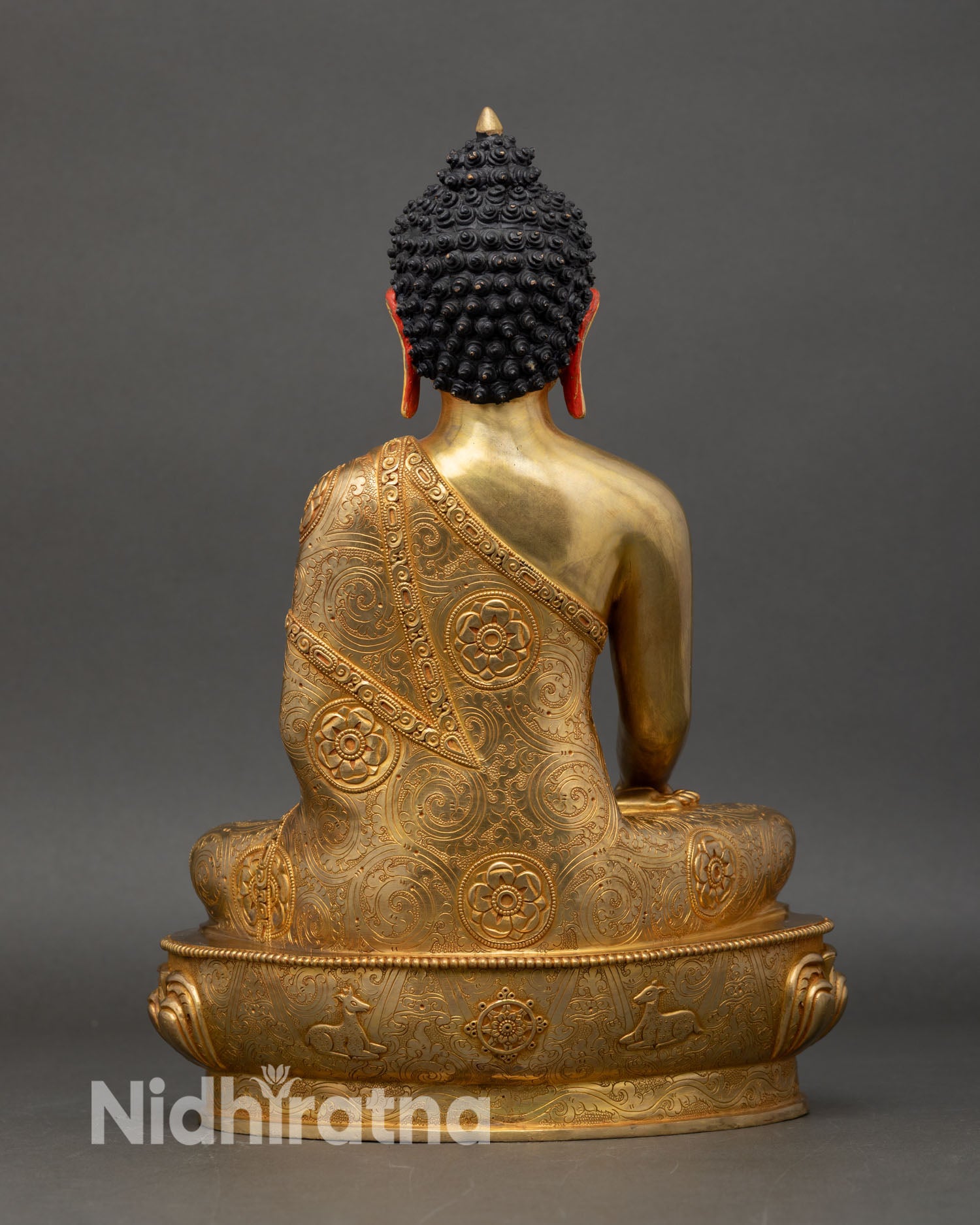 Back view of Shakyamuni Buddha statue intricate monastic robes scrollwork foliate patterns