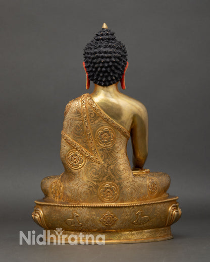 Back view of Shakyamuni Buddha statue intricate monastic robes scrollwork foliate patterns